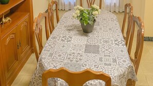 A dining room with a table set for six, surrounded by wooden chairs. A potted plant is on the table, and there are two wall-mounted decorations. - House with large patio/solarium near the beach, in the center. (Malgrat de Mar)