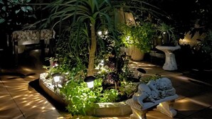 A well-lit garden area with various plants and a stone bench. - House with large patio/solarium near the beach, in the center. (Malgrat de Mar)