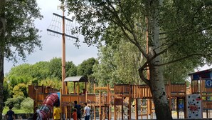 A playground with wooden structures and a red slide. - Large and quiet apartment 20 minutes from Venice (Venezia)