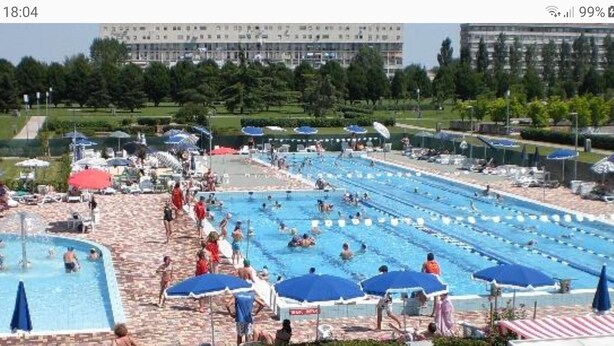 A swimming pool area with multiple lanes, sun loungers, and umbrellas. - Large and quiet apartment 20 minutes from Venice (Venezia)