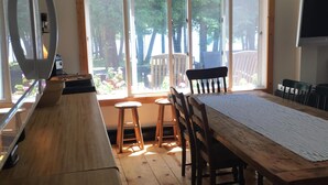 Una cocina con encimera de madera, estufa y comedor con mesa y sillas.