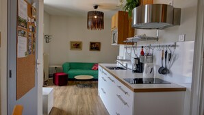Una cocina moderna con una isla integrada, electrodomésticos de acero inoxidable y una pata para colgar ollas.