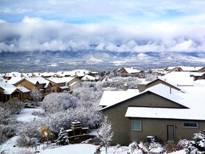 Un barrio residencial con casas cubiertas de nieve y montañas al fondo.