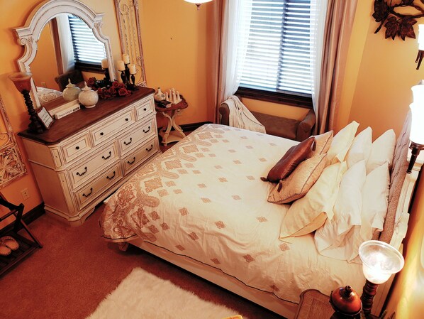 Un dormitorio con una cama grande, cómoda y un espejo.