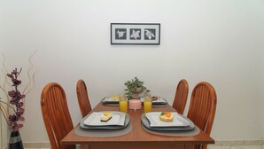A dining table with four chairs, a framed picture above, and a vase with purple flowers to the left. - Aida in Poreč - Istrien / Aida in Poreč - 1 Appartement für 4 Personen AP6 (Poreč)