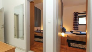 A compact hotel room with a bed, bedside table, and a mirror. - Aida in Poreč - Istrien / Aida in Poreč - 1 Appartement für 4 Personen AP6 (Poreč)