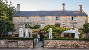 A stone building with a sign reading 'The Wild Rabbit' and outdoor seating with umbrellas. - Bentleys - Three Bedroom Cottage, Sleeps 6 (Kingham)