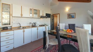 A kitchen with white cabinets, a wooden ceiling, a dining table with chairs, and a fruit bowl. - Aida in Poreč - Istrien / Aida in Poreč - 1 Appartement für 4-6 Personen AP7 (Porec)