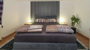 A neatly arranged bedroom with a large bed, two bedside tables, a headboard, and a potted plant. - Aida in Poreč - Istrien / Aida in Poreč - 1 Appartement für 4-6 Personen AP7 (Porec)