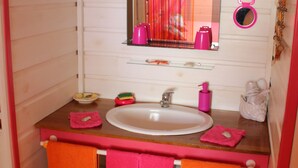 A bathroom with a wooden vanity, a white sink, and pink towels. - Coco Bungalows. Bungalows 2 / pers sea at 100m (Ste Rose)