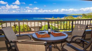 A balcony with a table set for two, overlooking a coastal view. - Kapalua Ridge Villa 1124 Luxury Oceanview Retreat (Lahaina)