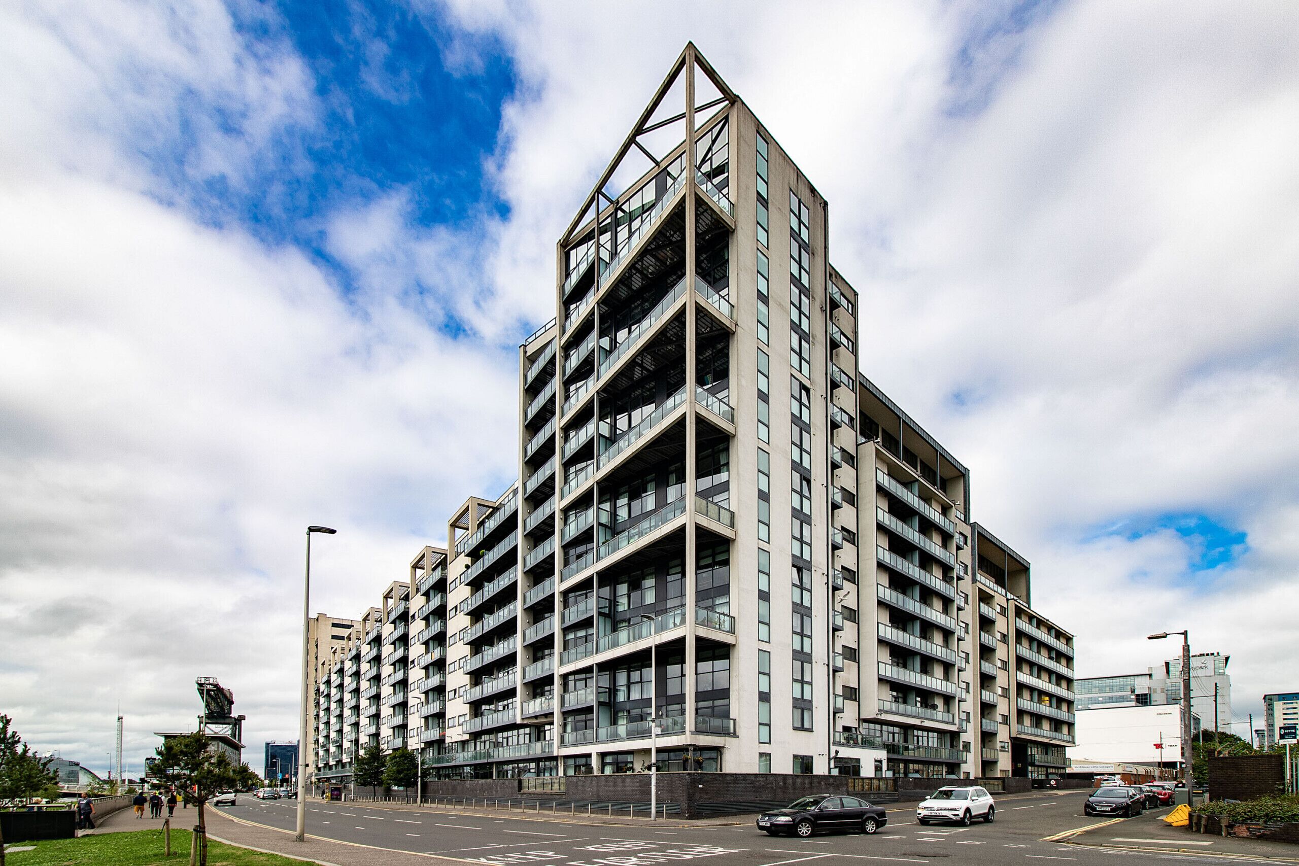A multi-story residential building with a modern architectural design, featuring balconies and large windows.