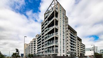A multi-story residential building with a modern architectural design, featuring balconies and large windows.