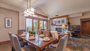 A dining area with a wooden table set for six, surrounded by upholstered chairs. - Iron Horse North - Luxury in the Northstar Village! (Truckee)