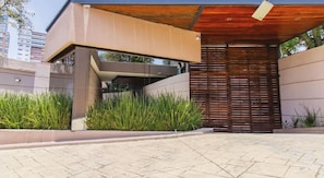 Stylish entrance with a large wooden door and concrete pillars.