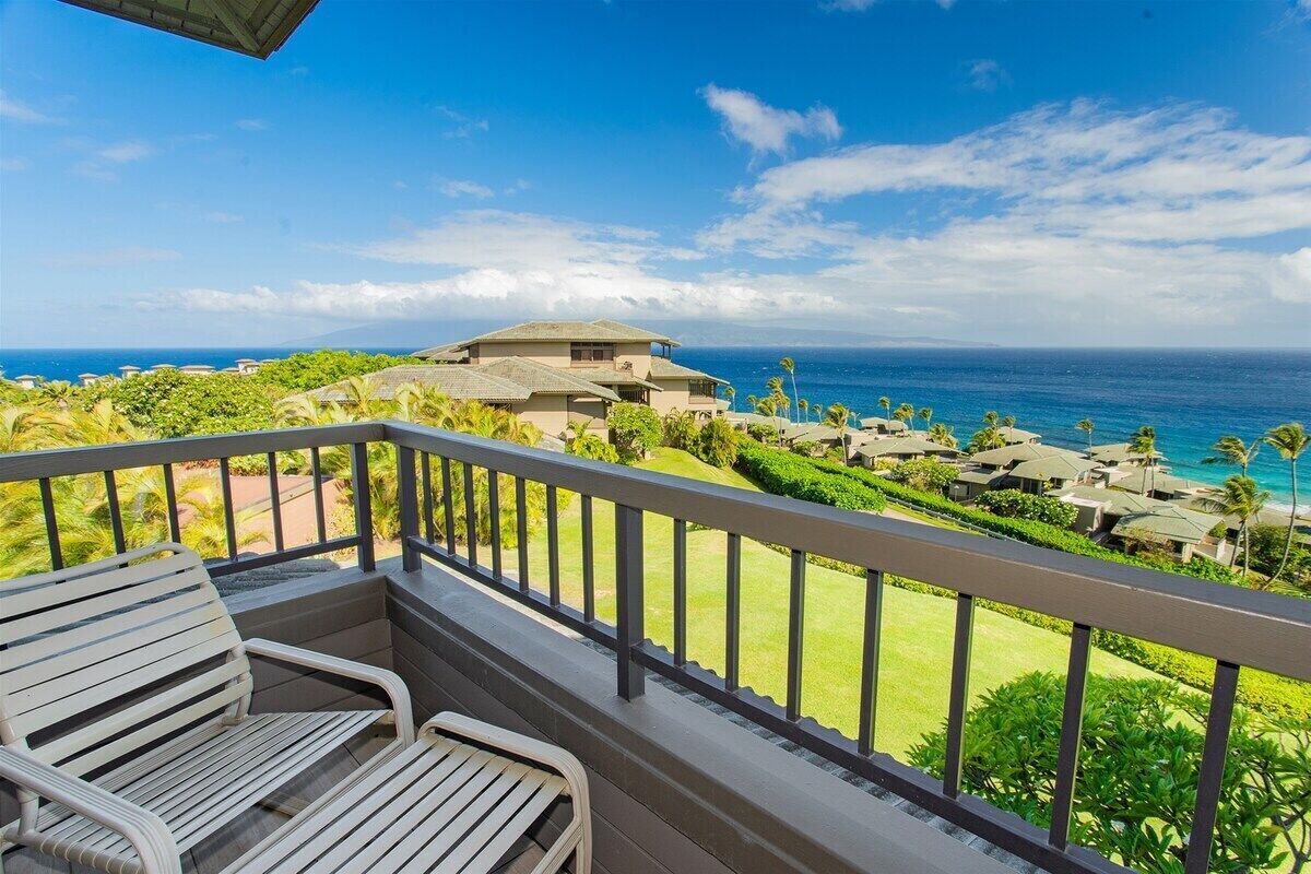 Un balcon avec vue sur l’océan et les bâtiments du complexe hôtelier.
