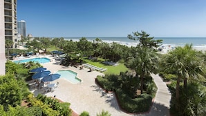 Ein Resort mit Schwimmbad, Strand und Palmen.
