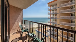 Ein Balkon mit Blick auf den Ozean und ein Gebäude mit mehreren Balkonen.