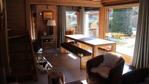Interior em madeira com uma mesa de jantar, um banco e uma cadeira aconchegante.