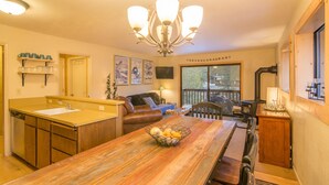A cozy living room with a wooden dining table, a sofa, and a fireplace.