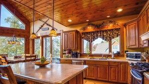 Une cuisine spacieuse avec des meubles en bois, un grand îlot central et des luminaires suspendus.
