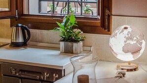 A kitchen with a window, a kettle, a plant, and a globe. - In the ancient Jewish ghetto (Ferrara)