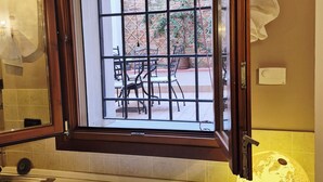 A bathroom with a window, a globe, and a tiled wall. - In the ancient Jewish ghetto (Ferrara)