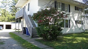 Ett tvåvåningshus med en veranda framtill, en trappa och ett garage.