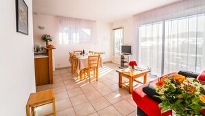 A spacious living area with a dining table, chairs, a sofa, and a TV. - Chalet 4-6 pers. - Albaret-le-Comtal (Albaret-le-Comtal)