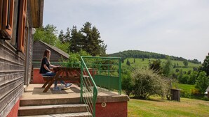 A wooden building with a staircase leading to a porch. - Chalet 4-6 pers. - Albaret-le-Comtal (Albaret-le-Comtal)