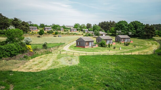 A rural setting with multiple small houses, a grassy field, and a dirt path. - Chalet 4-6 pers. - Albaret-le-Comtal (Albaret-le-Comtal)