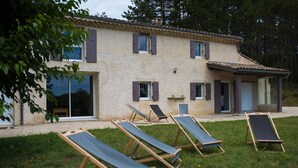 A two-story building with a tiled roof, multiple windows with shutters, and a covered patio area with sun loungers. - In nature, 3 bedroom house sleeps 8-10, totally renovated in 2019 (Aouste-sur-Sye)