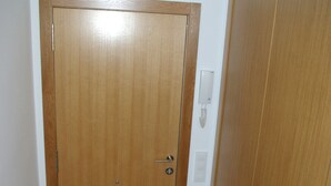 A wooden door with a handle and a lock, a light switch, and a power outlet on the wall. - Central apartment in Moraira (Moraira)