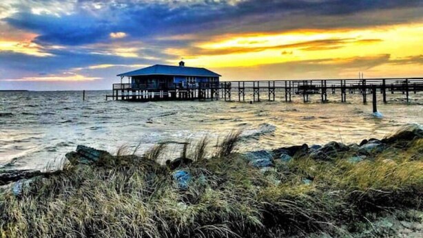A coastal pier with a single blue-roofed structure, extending into the sea. - On Jockey Ridge State Park + Hot Tub & Center of OBX (Nags Head)