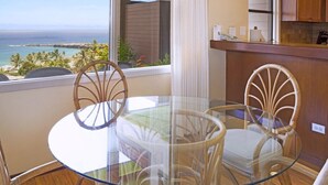 A glass-top table with wicker chairs, a kitchen counter, and a view of the ocean. - Kapalua Ridge 2012- Whale Watching Ocean Views (Lahaina)