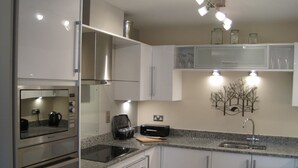 Una cucina moderna con elettrodomestici in acciaio inossidabile, piani in granito e forno integrato.