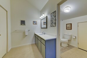 A bathroom with a white sink, mirror, and toilet. There are framed pictures on the wall and a towel rack. - Rustic Ski Lodge - within minutes of Alta and Snowbird (Alta)