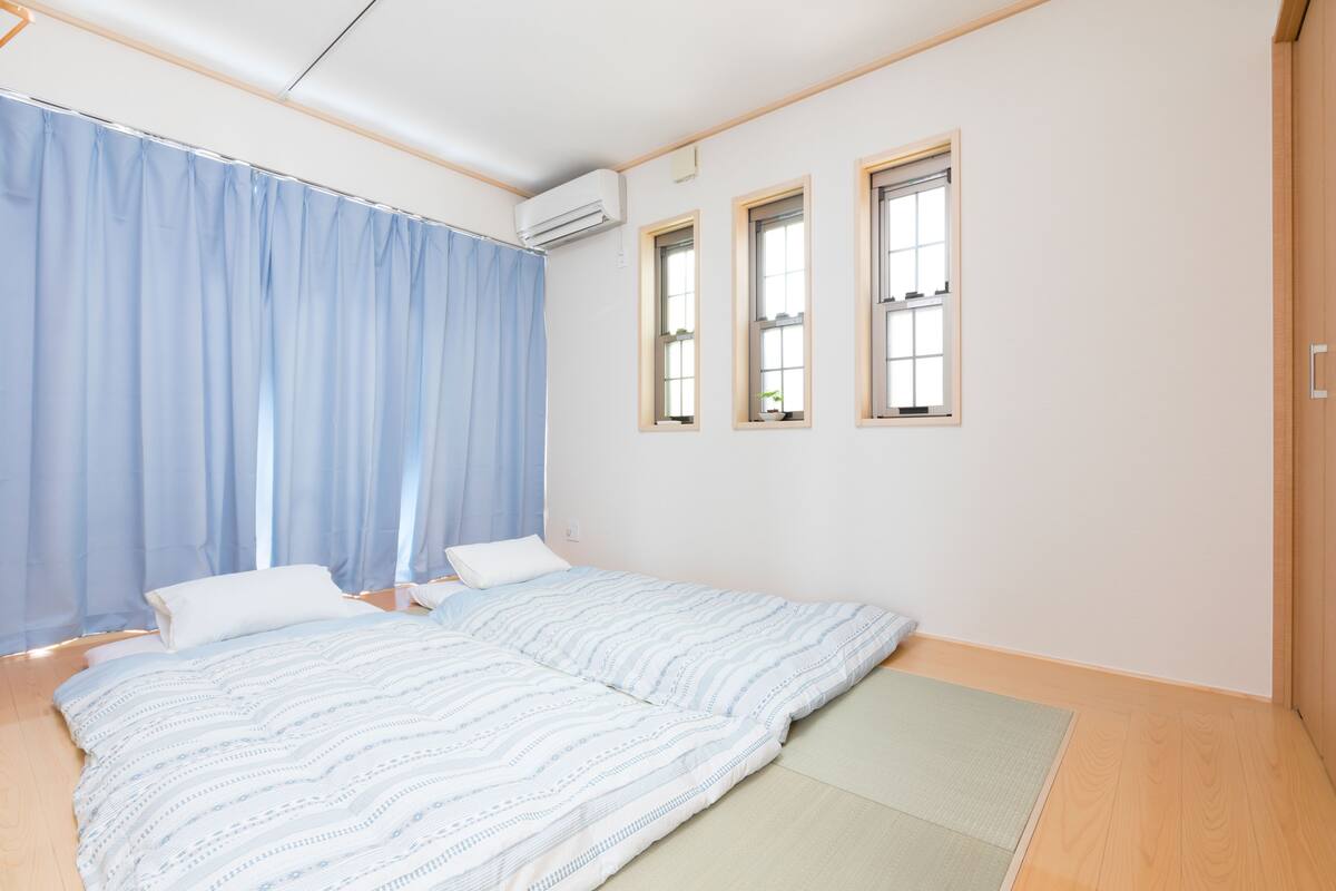 A bedroom with a bed, a window, and an air conditioning unit.