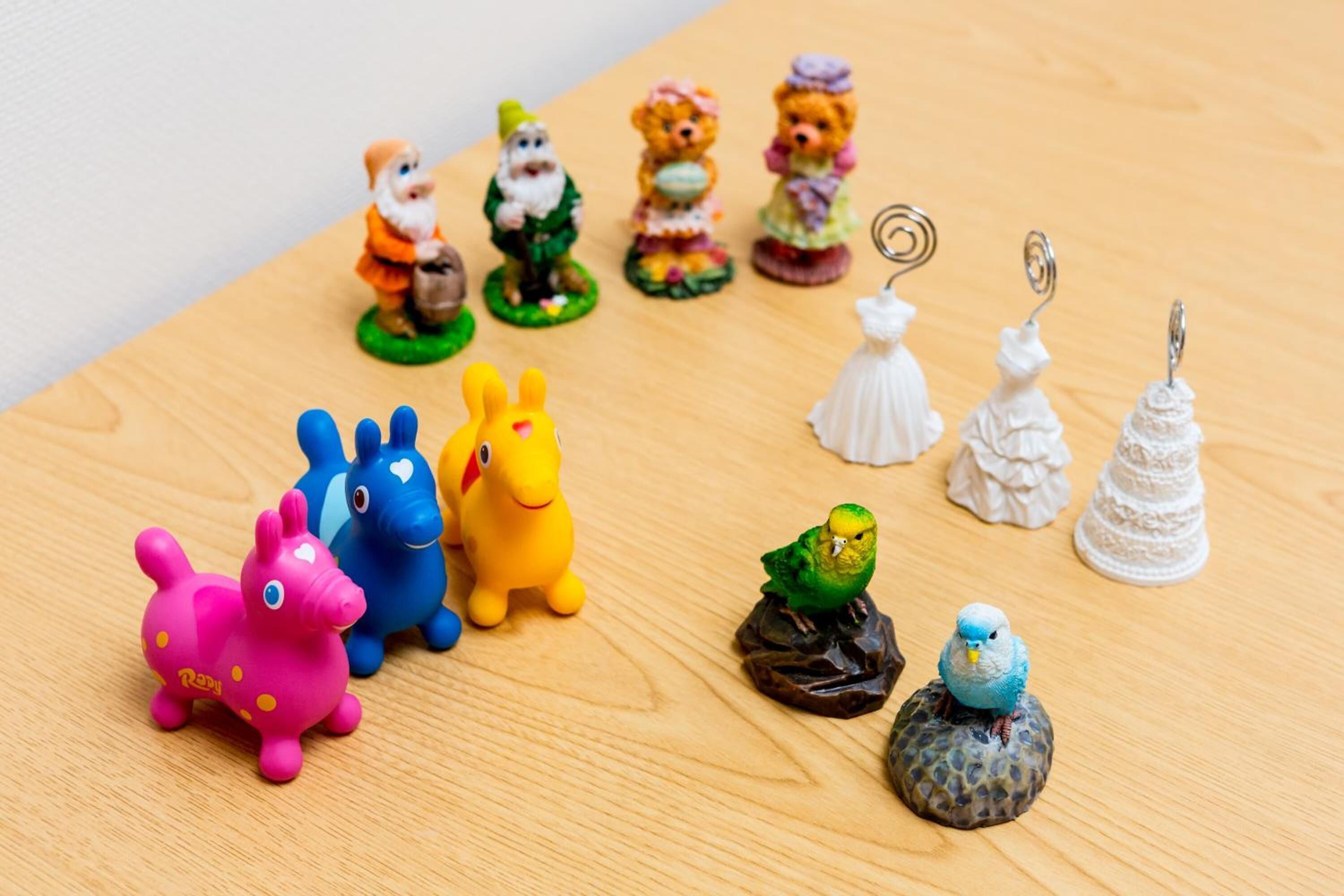 Una colección de pequeñas figuras y llaveros sobre una superficie de madera.