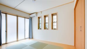 Une pièce avec des tatamis, des portes coulissantes et une armoire en bois.