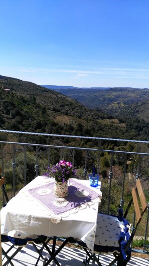 Une table dressée à l’extérieur, avec vue sur un paysage montagneux.