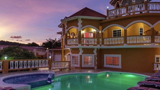 A large, multi-story building with a swimming pool and outdoor seating area.