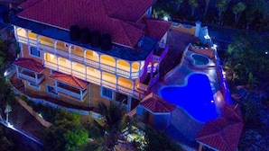 A large, multi-story building with a swimming pool and a tennis court.