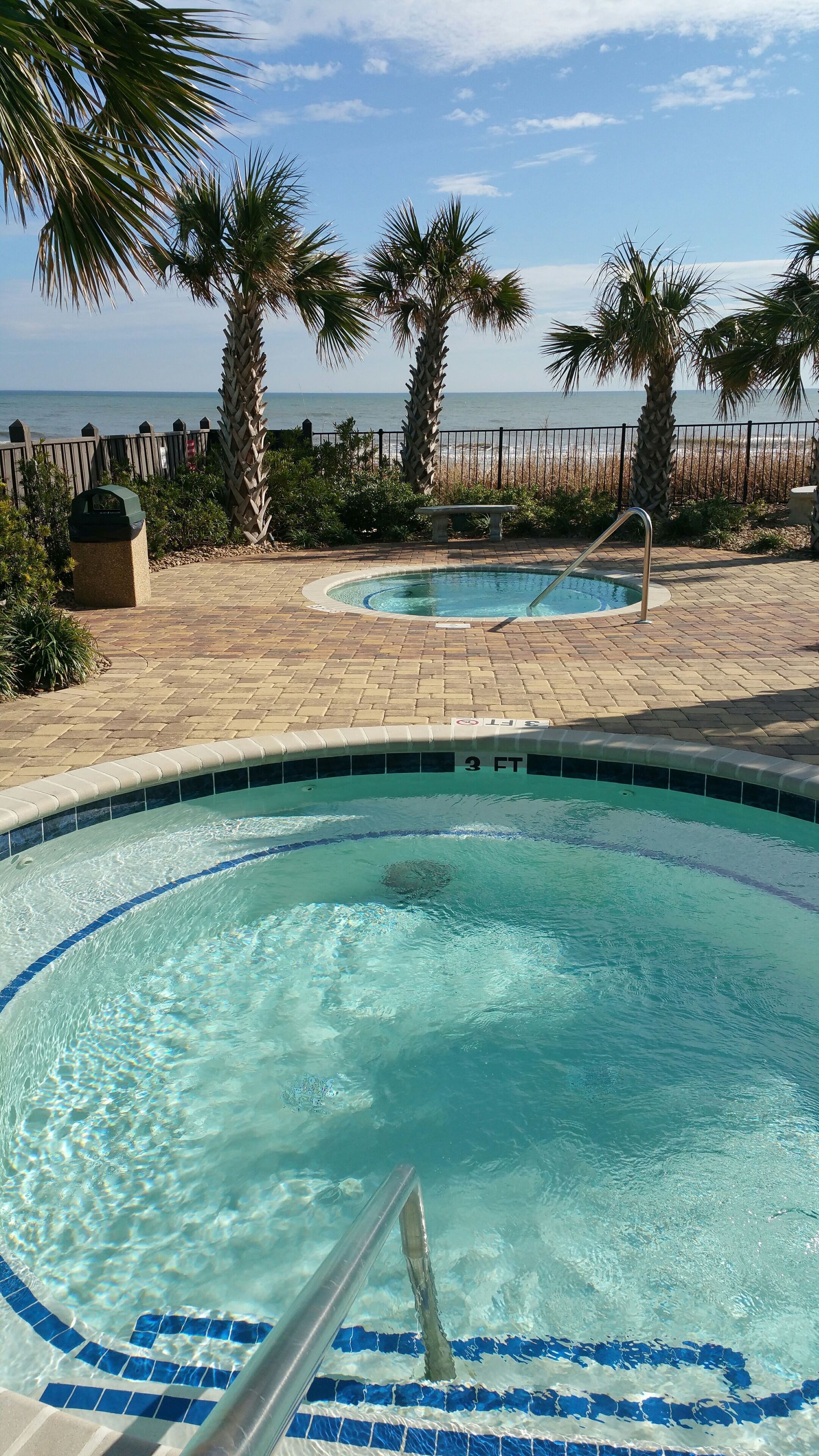 A swimming pool with a view of the beach and ocean.