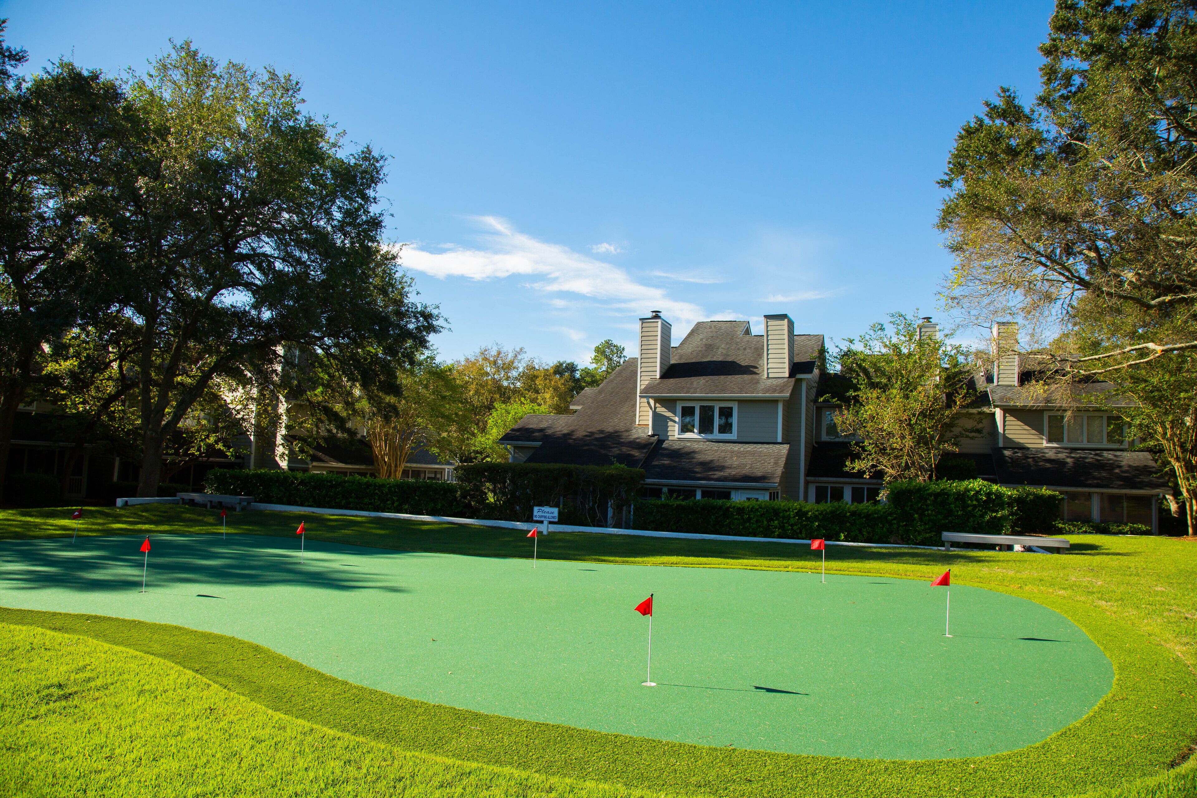 A golf course with a house in the background.