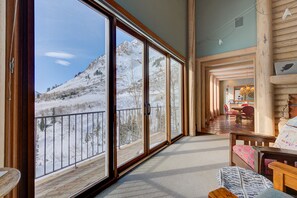 A spacious room with large sliding glass doors leading to a balcony with a snowy mountain view. - Ski Country's Rare Gem (Alta)