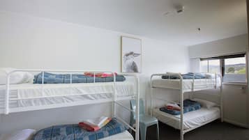Un dormitorio con literas, una ventana con vistas y un ventilador de techo.
