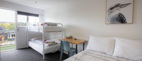 Una habitación con literas, un escritorio, una silla y una cama.