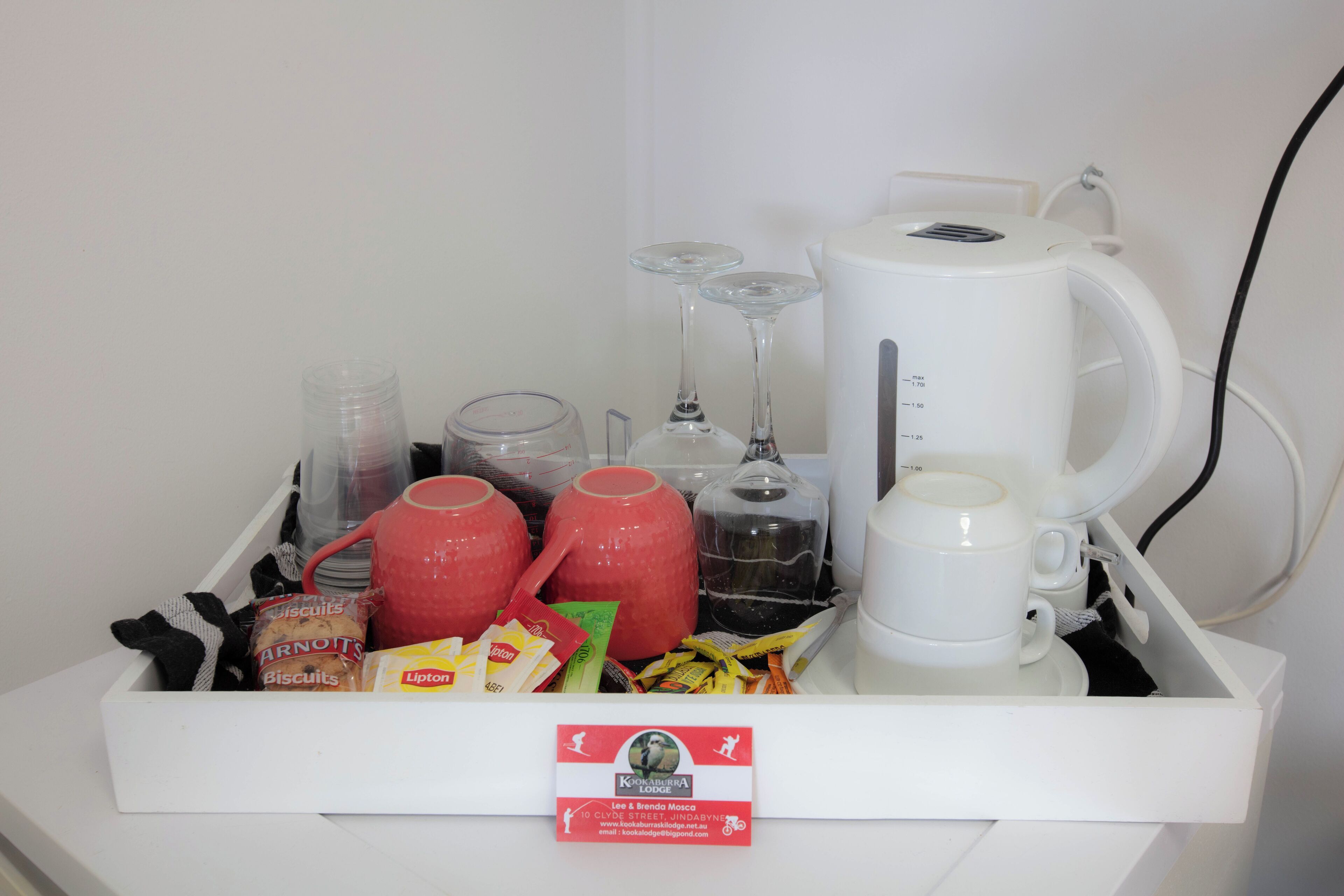 A breakfast tray with various items including a coffee maker, teapot, cups, and snacks.