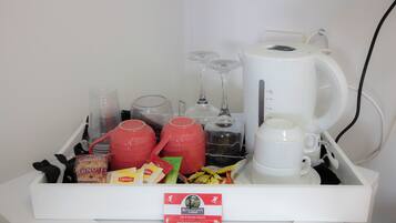 A breakfast tray with various items including a coffee maker, teapot, cups, and snacks.